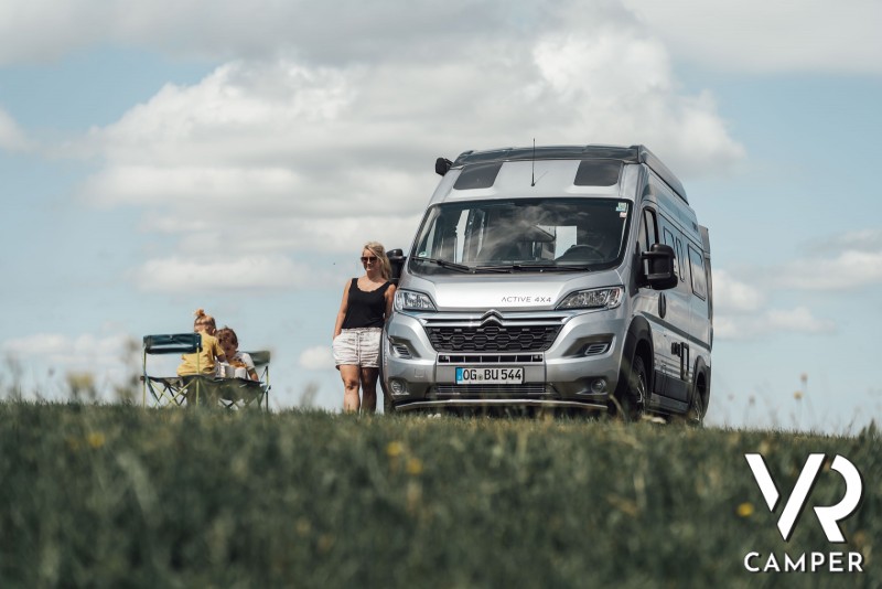 coppia con camper furgonato su prato - guida al noleggio camper